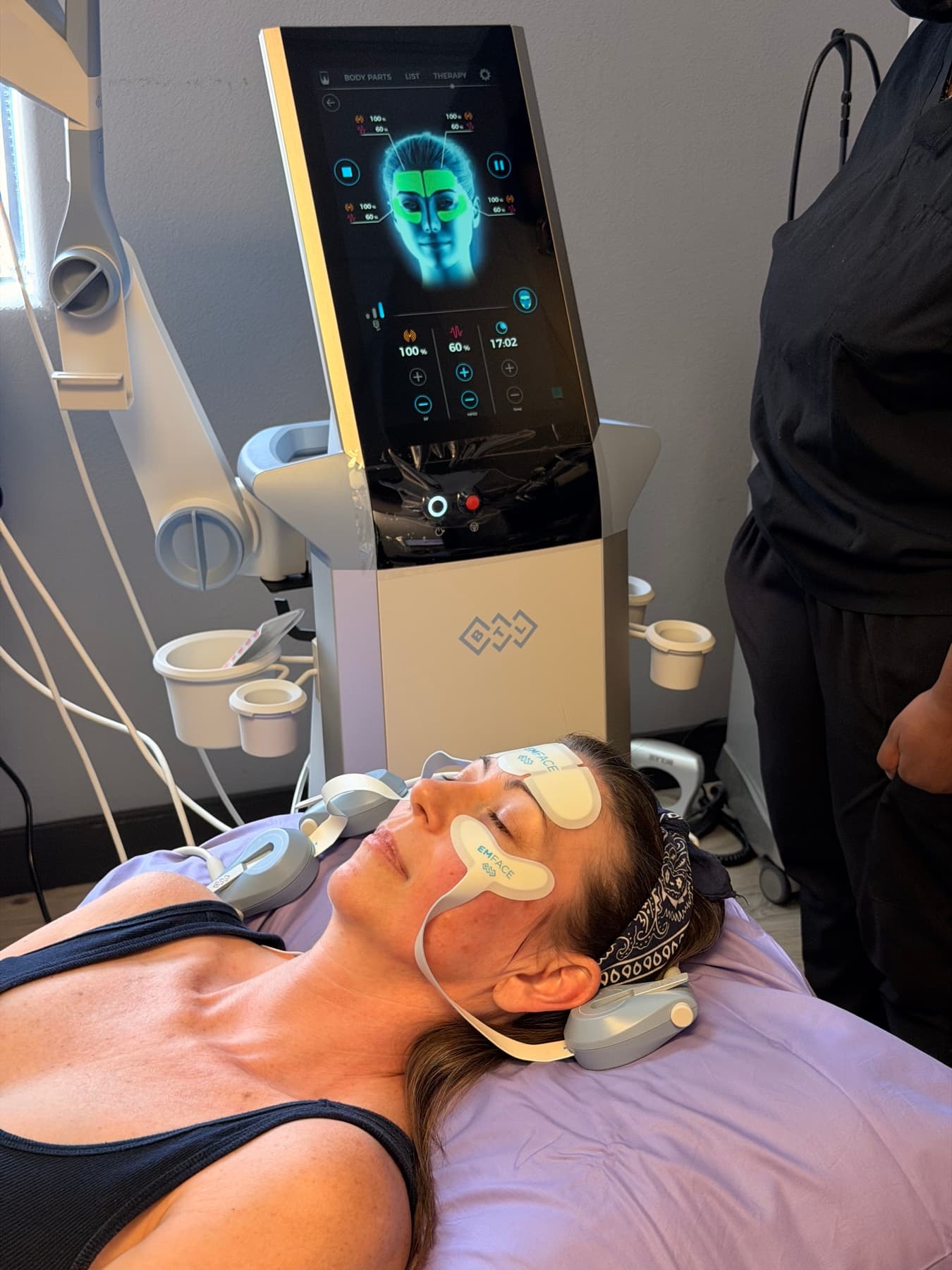 Dr. Goh's EMFACE patient mid-session — applicator pads in place
